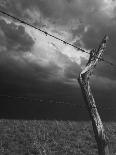 On a Small Farm, Ominous Clouds Overhead, Outlined by Barbed Wire Fencing-Nat Farbman-Photographic Print