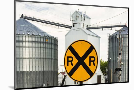 Nebraska, Blair, Washington County. Grain silo and equipment on Front Street, RR crossing sign.-Alison Jones-Mounted Photographic Print