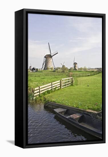 Netherlands, Kinderdijk. Windmills and boat next to canal.-Jaynes Gallery-Framed Premier Image Canvas