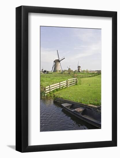 Netherlands, Kinderdijk. Windmills and boat next to canal.-Jaynes Gallery-Framed Photographic Print