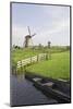 Netherlands, Kinderdijk. Windmills and boat next to canal.-Jaynes Gallery-Mounted Photographic Print