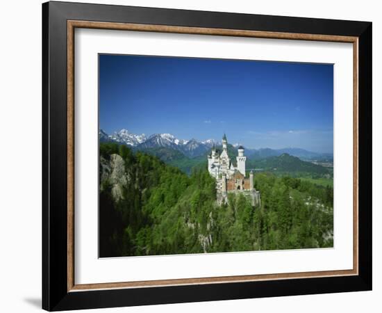 Neuschwanstein Castle on a Wooded Hill with Mountains in the Background, in Bavaria, Germany-null-Framed Photographic Print