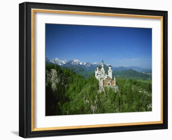 Neuschwanstein Castle on a Wooded Hill with Mountains in the Background, in Bavaria, Germany-null-Framed Photographic Print