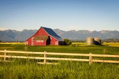 Summer Evening with a Red Barn and Silos in Rural Montana with Rocky Mountains in the Background.-Nick Fox-Photographic Print
