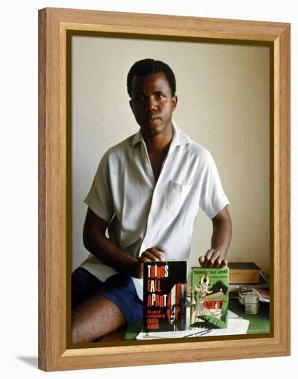 Nigerian Author Chinua Achebe Holding Two Editions of His Book Things Fall Apart-Eliot Elisofon-Framed Premier Image Canvas