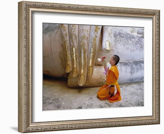 Novice Buddhist Monk Kneeling Beneath the Phra Atchana Buddha Statue, Sukhothai Province, Thailand-Gavin Hellier-Framed Photographic Print