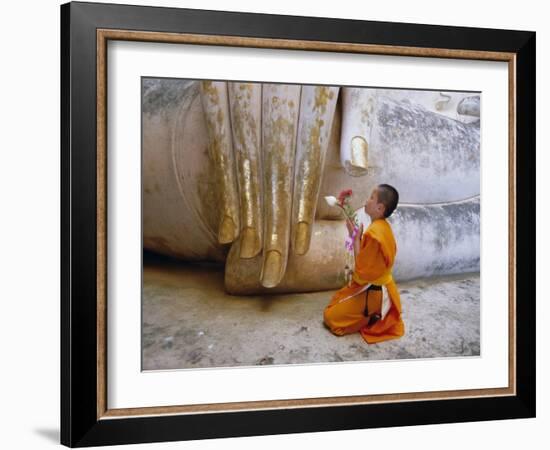 Novice Buddhist Monk Kneeling Beneath the Phra Atchana Buddha Statue, Sukhothai Province, Thailand-Gavin Hellier-Framed Photographic Print