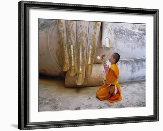 Novice Buddhist Monk Kneeling Beneath the Phra Atchana Buddha Statue, Sukhothai Province, Thailand-Gavin Hellier-Framed Photographic Print