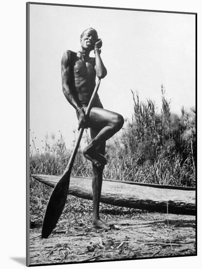 Nuer Tribesman Standing Like a Stork Next to His Canoe in a Papyrus Swamp-Eliot Elisofon-Mounted Photographic Print