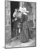 Nun from the Order of Sisters of Charity Visiting a Destitute Family with Supplies-null-Mounted Photographic Print