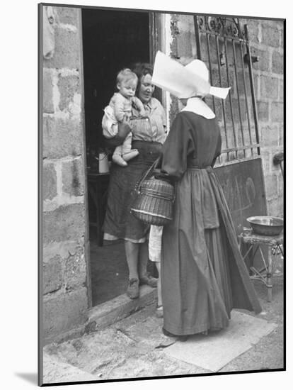 Nun from the Order of Sisters of Charity Visiting a Destitute Family with Supplies-null-Mounted Photographic Print