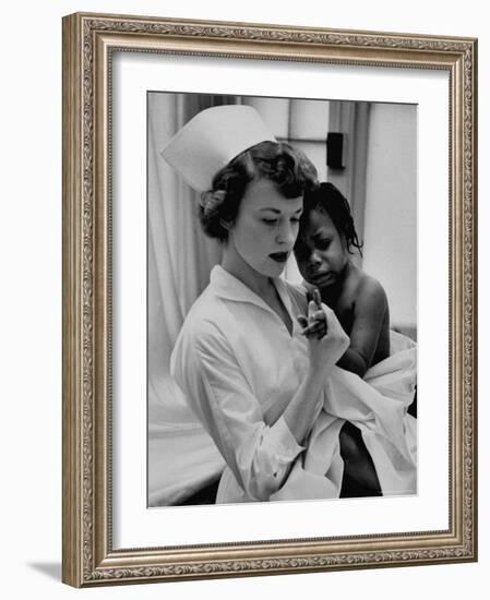 Nurse Holding African American Girl in Her Arms, Examining Her Finger-John Dominis-Framed Photographic Print