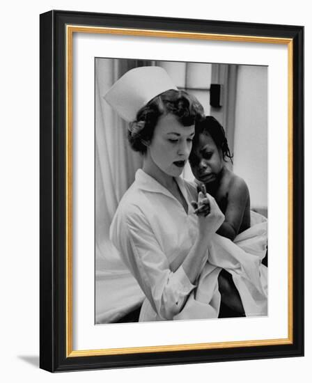 Nurse Holding African American Girl in Her Arms, Examining Her Finger-John Dominis-Framed Photographic Print