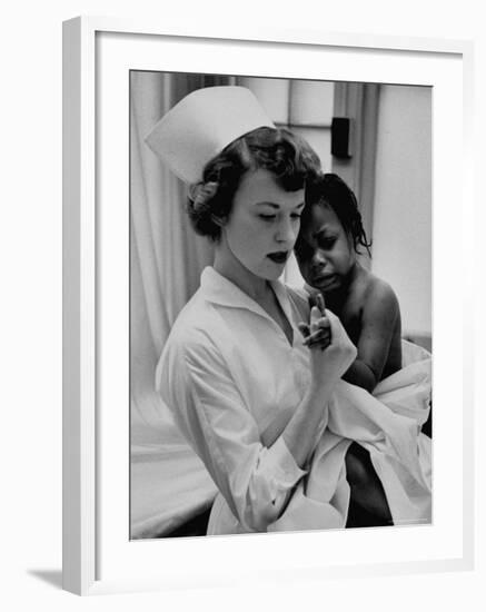 Nurse Holding African American Girl in Her Arms, Examining Her Finger-John Dominis-Framed Photographic Print