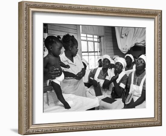 Nurse/Midwife Maude Callen Holds Baby and Teaches Class in Midwifery How to Look for Abnormalities-W^ Eugene Smith-Framed Photographic Print