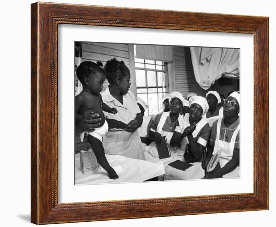 Nurse/Midwife Maude Callen Holds Baby and Teaches Class in Midwifery How to Look for Abnormalities-W^ Eugene Smith-Framed Photographic Print