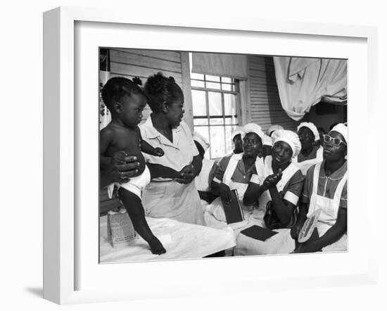 Nurse/Midwife Maude Callen Holds Baby and Teaches Class in Midwifery How to Look for Abnormalities-W^ Eugene Smith-Framed Photographic Print