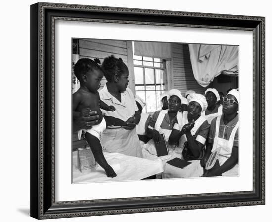 Nurse/Midwife Maude Callen Holds Baby and Teaches Class in Midwifery How to Look for Abnormalities-W^ Eugene Smith-Framed Photographic Print