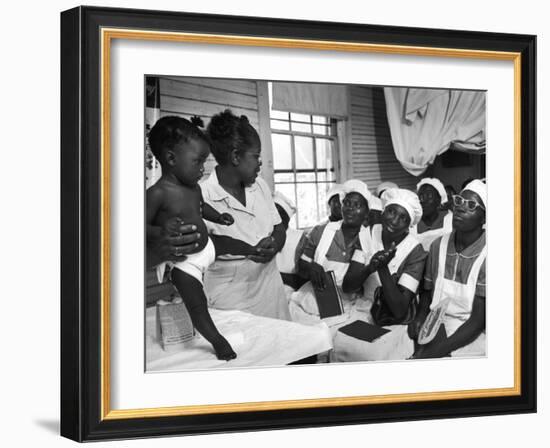 Nurse/Midwife Maude Callen Holds Baby and Teaches Class in Midwifery How to Look for Abnormalities-W^ Eugene Smith-Framed Photographic Print