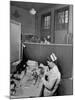 Nurse Sitting at Table with Medical Supplies While Doctors Examine Patient in Background-Wallace Kirkland-Mounted Premium Photographic Print