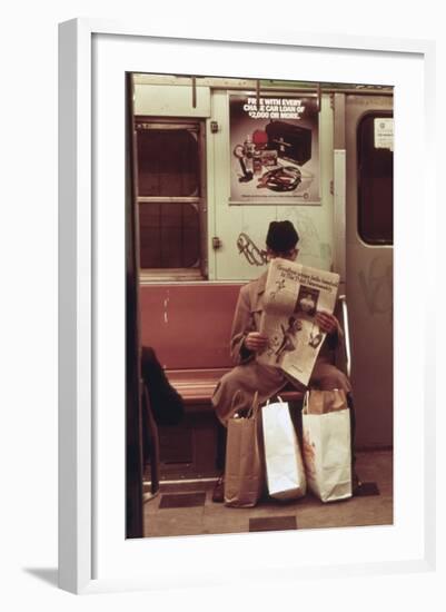 NYC Subway Passenger Reading Newspaper with Shopping Bags in May 1973-null-Framed Photo