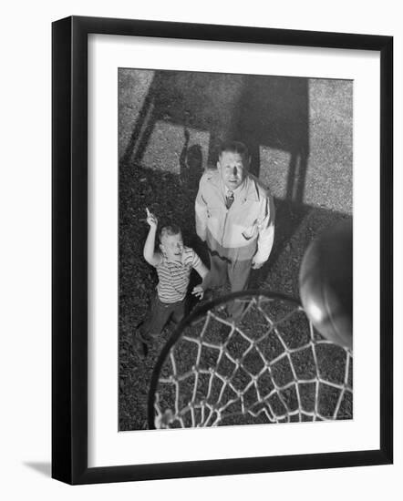 Oklahoma A&M Basketball Coach Hank Iba Watching a Young Boy Shooting a Basket-Myron Davis-Framed Photographic Print