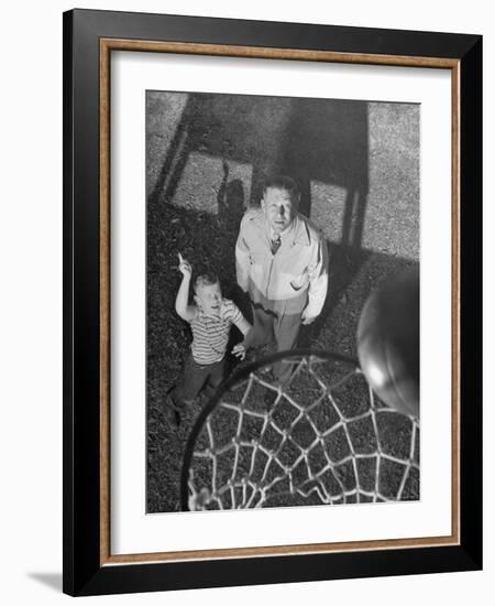 Oklahoma A&M Basketball Coach Hank Iba Watching a Young Boy Shooting a Basket-Myron Davis-Framed Photographic Print