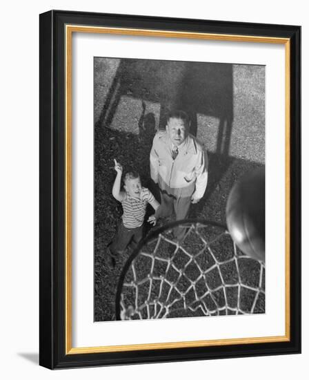 Oklahoma A&M Basketball Coach Hank Iba Watching a Young Boy Shooting a Basket-Myron Davis-Framed Photographic Print