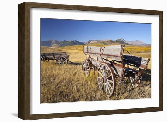 Old Horse-Drawn Wagons with the Rocky Mountains in the Background, Alberta, Canada-Miles Ertman-Framed Photographic Print