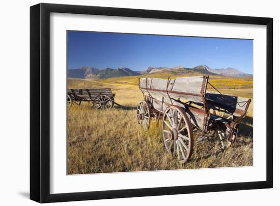 Old Horse-Drawn Wagons with the Rocky Mountains in the Background, Alberta, Canada-Miles Ertman-Framed Photographic Print