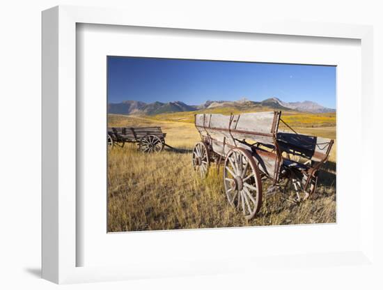 Old Horse-Drawn Wagons with the Rocky Mountains in the Background, Alberta, Canada-Miles Ertman-Framed Photographic Print