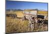 Old Horse-Drawn Wagons with the Rocky Mountains in the Background, Alberta, Canada-Miles Ertman-Mounted Photographic Print