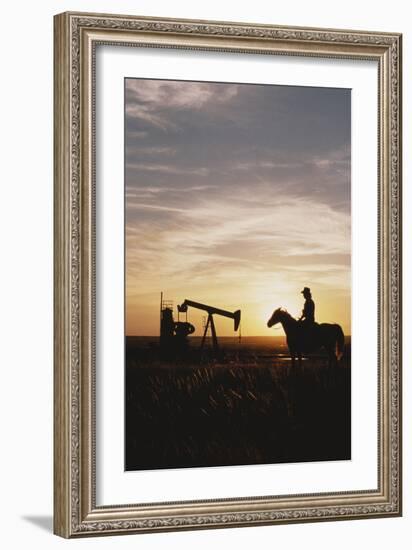 Old West, New West, Man Sitting on Horse with Oil Refinery at Sunset-David R^ Frazier-Framed Photographic Print