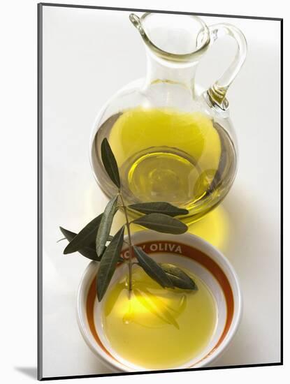 Olive Oil with Olive Branch in Bowl in Front of Carafe-null-Mounted Photographic Print