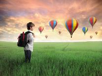 Child Carrying A Backpack Standing On A Green Meadow With Hot-Air Balloons In The Background-olly2-Art Print