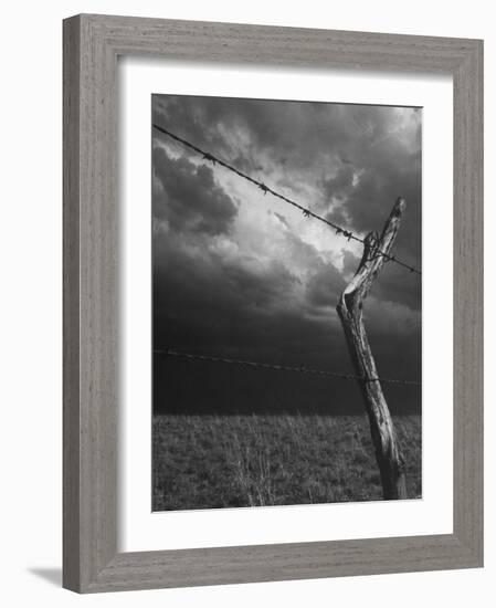 On a Small Farm, Ominous Clouds Overhead, Outlined by Barbed Wire Fencing-Nat Farbman-Framed Photographic Print