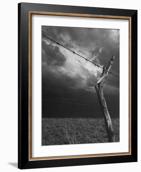 On a Small Farm, Ominous Clouds Overhead, Outlined by Barbed Wire Fencing-Nat Farbman-Framed Photographic Print