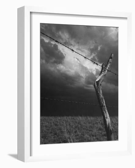 On a Small Farm, Ominous Clouds Overhead, Outlined by Barbed Wire Fencing-Nat Farbman-Framed Photographic Print