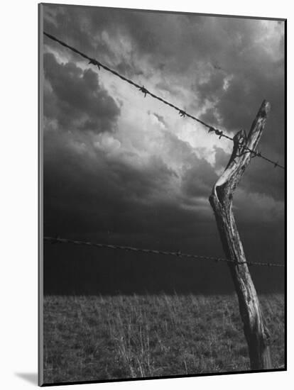 On a Small Farm, Ominous Clouds Overhead, Outlined by Barbed Wire Fencing-Nat Farbman-Mounted Photographic Print