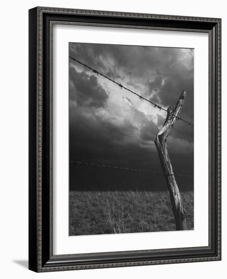 On a Small Farm, Ominous Clouds Overhead, Outlined by Barbed Wire Fencing-Nat Farbman-Framed Photographic Print