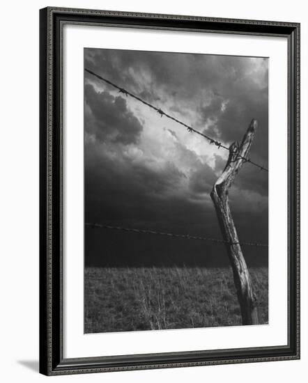 On a Small Farm, Ominous Clouds Overhead, Outlined by Barbed Wire Fencing-Nat Farbman-Framed Photographic Print