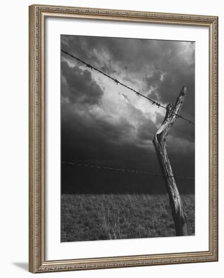 On a Small Farm, Ominous Clouds Overhead, Outlined by Barbed Wire Fencing-Nat Farbman-Framed Photographic Print