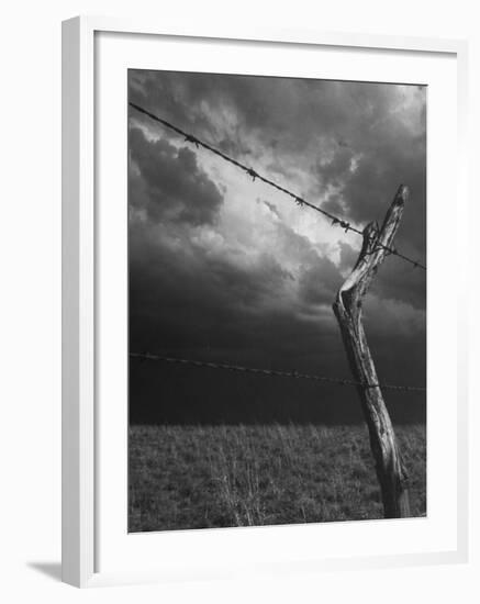 On a Small Farm, Ominous Clouds Overhead, Outlined by Barbed Wire Fencing-Nat Farbman-Framed Photographic Print