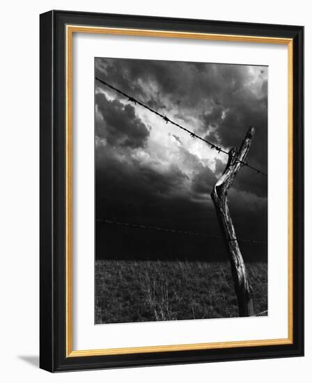 On a Small Farm, Ominous Clouds Overhead, Outlined by Barbed Wire Fencing-Nat Farbman-Framed Photographic Print