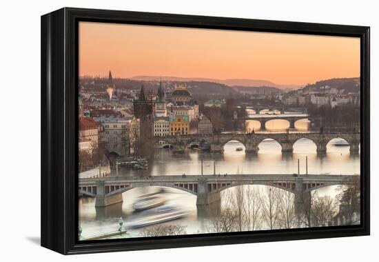 Orange sky at sunset on the historical bridges and buildings reflected on Vltava River, Prague, Cze-Roberto Moiola-Framed Premier Image Canvas