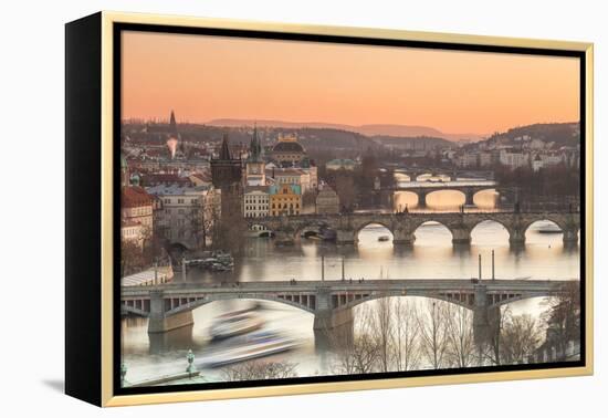 Orange sky at sunset on the historical bridges and buildings reflected on Vltava River, Prague, Cze-Roberto Moiola-Framed Premier Image Canvas