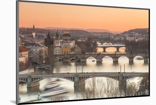 Orange sky at sunset on the historical bridges and buildings reflected on Vltava River, Prague, Cze-Roberto Moiola-Mounted Photographic Print