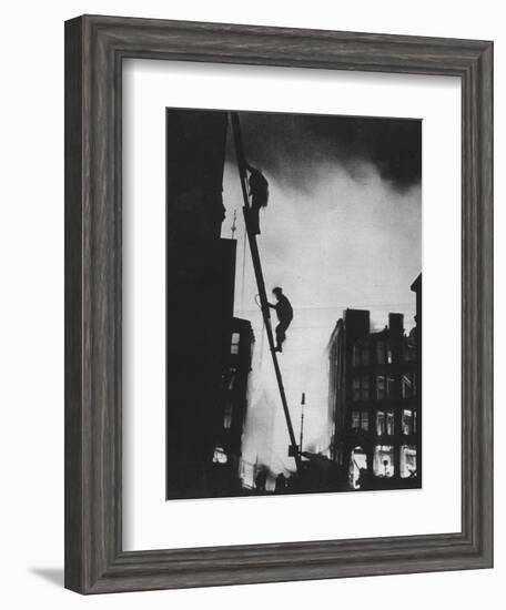 'Out in the Blitz, silhouetted aganinst the light of fires, rescue men climb into a building in St-Unknown-Framed Photographic Print