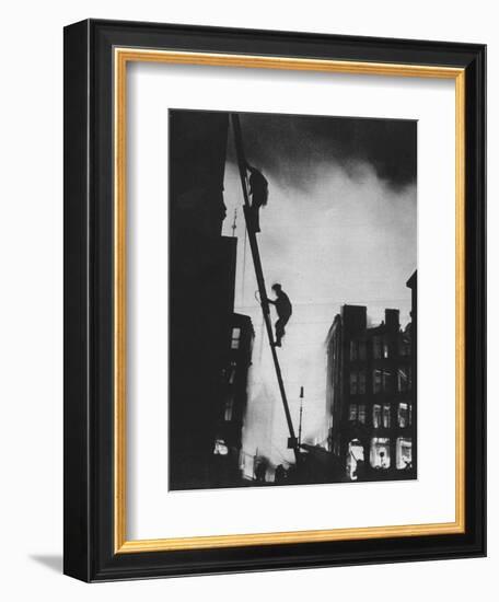 'Out in the Blitz, silhouetted aganinst the light of fires, rescue men climb into a building in St-Unknown-Framed Photographic Print