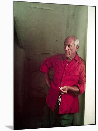Pablo Picasso Leaning Against Wall and Holding Smoldering Cigarette-Gjon Mili-Mounted Premium Photographic Print
